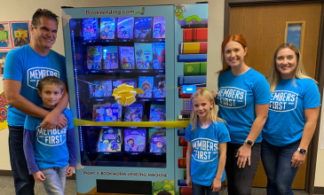 Members First Credit Union’s Chelsea McKenzie and Kristen Williamson celebrate the ribbon-cutting of a new book-vending machine with Jeff Calhoun, Director of Mid-Michigan Big Brothers Big Sisters, and two excited students from Farwell Elementary! 